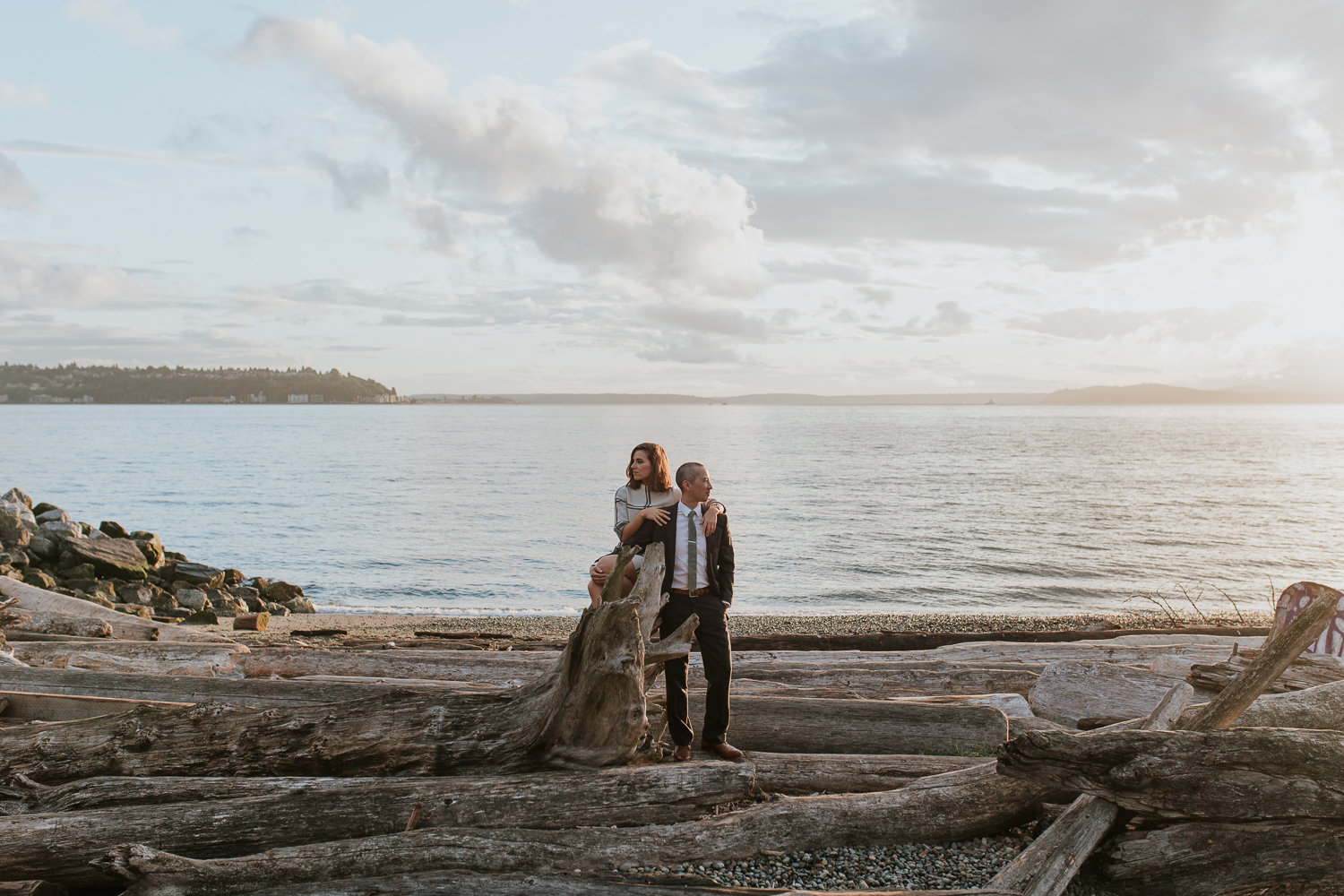 Gorgeous couple on a Seattle beach at sunset with overcast skies.