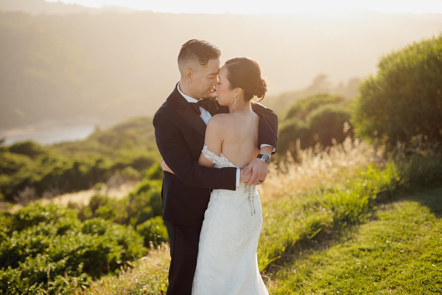 bride and groom huggin romantically during sunset